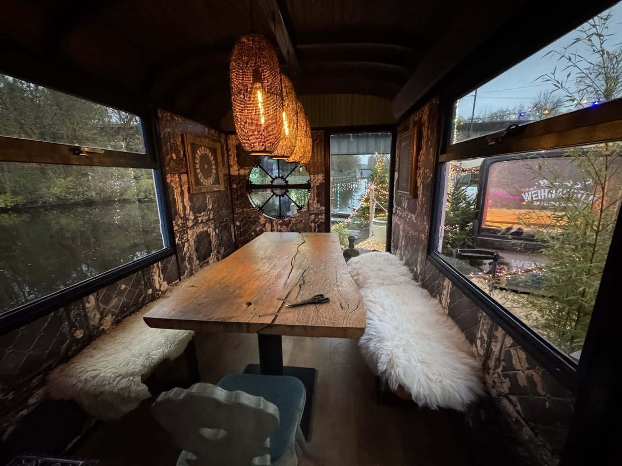 Lange Holztafel mit Fellen im Wahrsagerwagen, durch die Fenster der Blick aufs Wasser